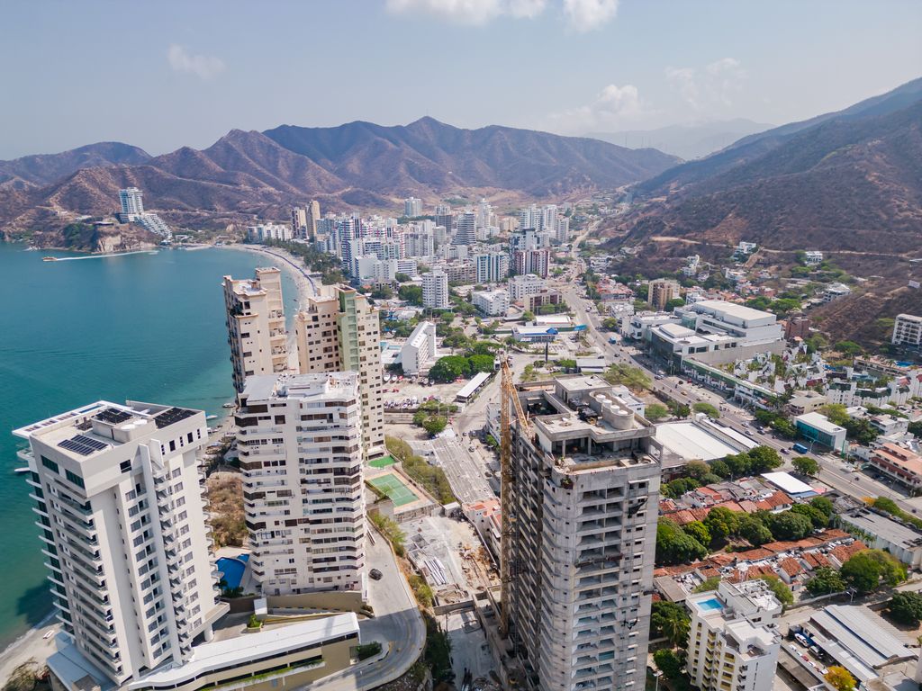 Drone shot of Santa Marta, Colombia showcasing urban skyline, coastline, and surrounding hills.